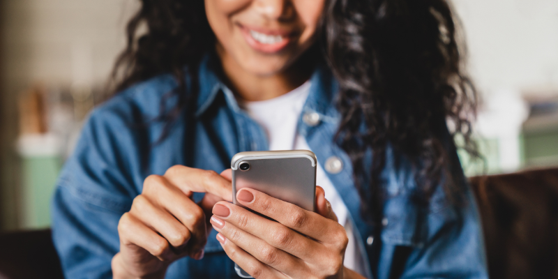 Smiling Woman Scrolls an SERP Search Engine Results Page on Her Phone