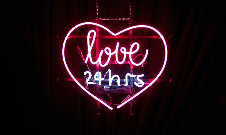 pink heart shaped neon with love 24hrs in text within the heart