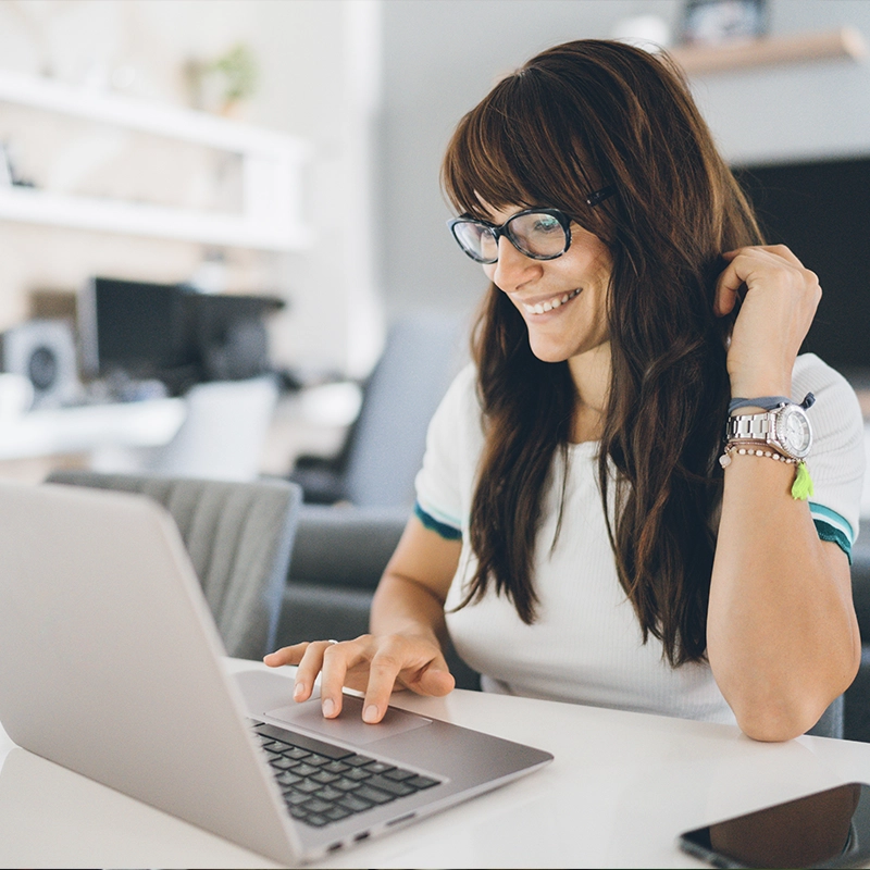 image of young woman smiling using laptop computer in home office