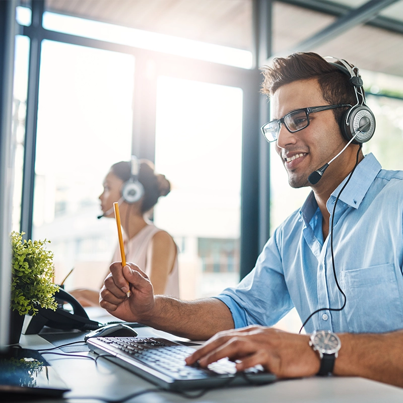 image of two support technicians supporting clients over the phone in an office