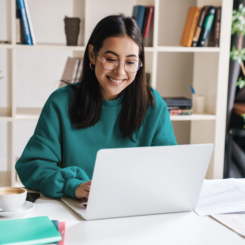 image of young woman smiling using laptop computer in home office