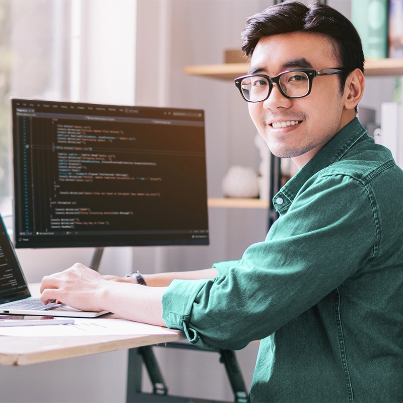 image of young man smiling using laptop computer in home office